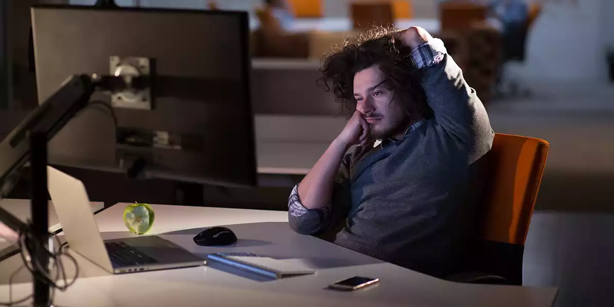 A-player-sitting-at-a-computer-looking-tired-and-ready-to-fall-asleep
