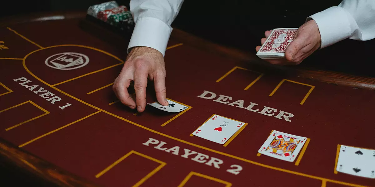 A-professional-dealer-working-at-a-physical-casino-table,-dealing-cards-to-players