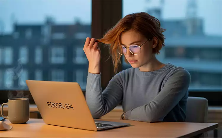 Person-sitting-in-front-of-their-laptop-desktop-tugging-at-their-hair-in-frustration