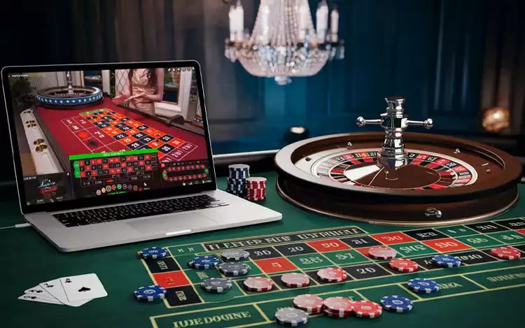 Photo of laptop and roulette wheel on a table