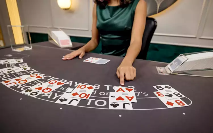 blackjack dealer pointing to a card