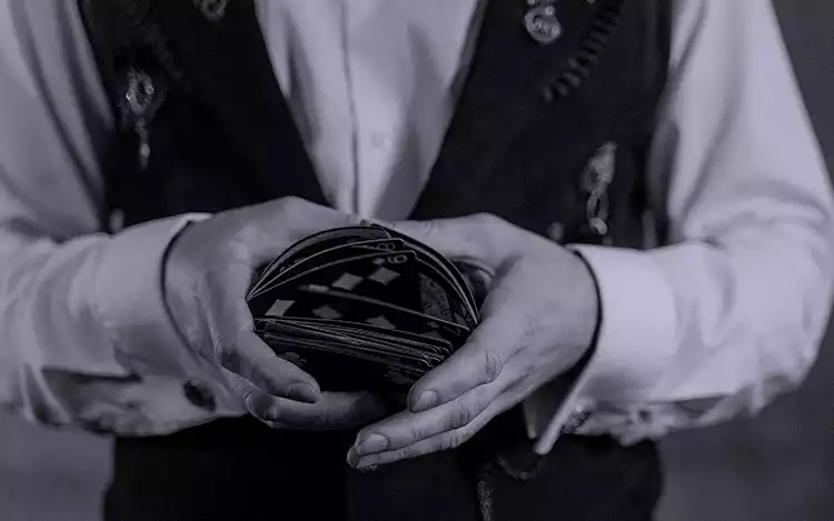 dealer shuffling cards on table
