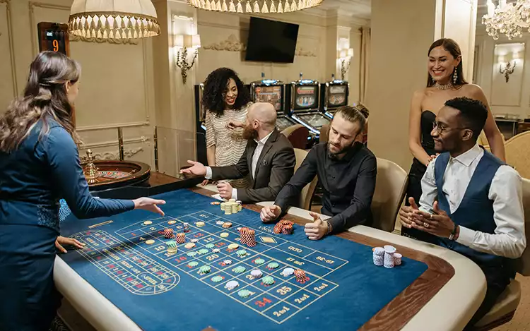 people in suits gathered around a roulette wheel