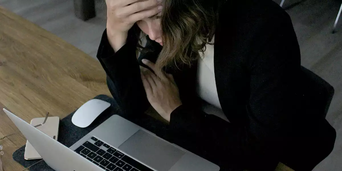 person-sitting-infront-of-a-laptop-looking-upset