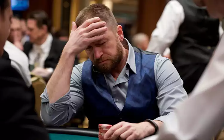 player with their head in their hands at the card table