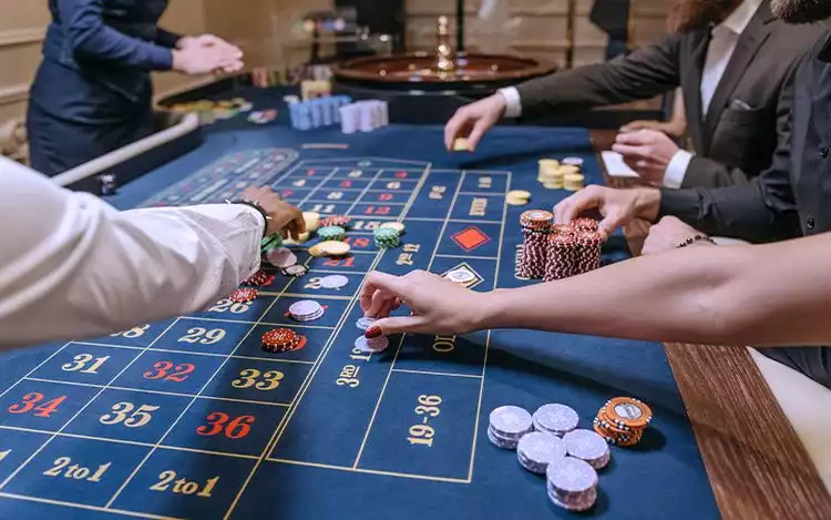 an image showing people playing cards and coins on a table