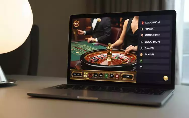 Modern online live european roulette interface on a laptop screen, with chat box showing polite player messages like 'thanks' and 'good luck'