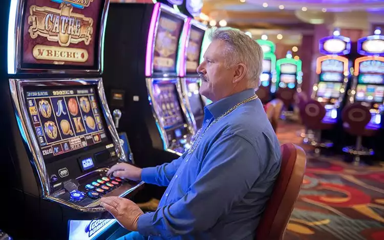 man playing slot machine in casino