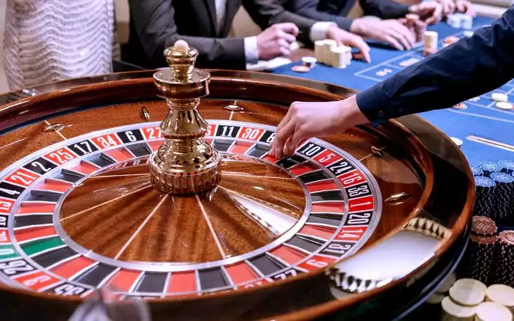 a Croupier about to toss the ball on a roulette game