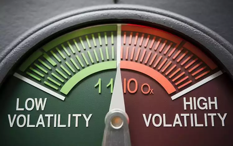 a symbolic depiction of slot volatility as a meter with low volatility on the left and high volatility on the right overlay on slot reels