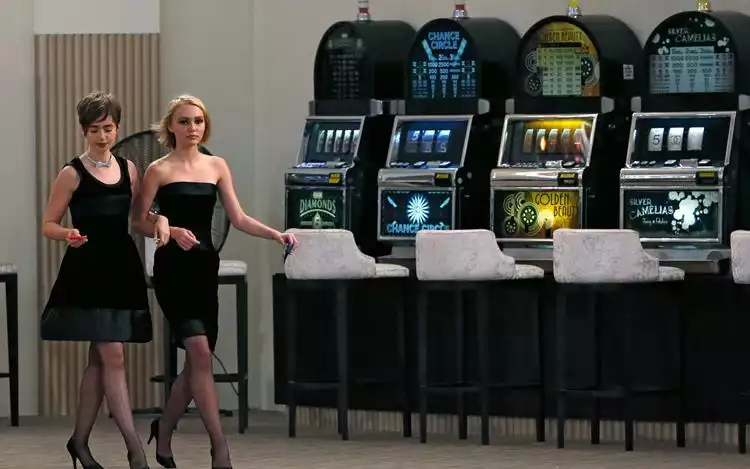 two female celebrities walking by chanel-branded slot machines