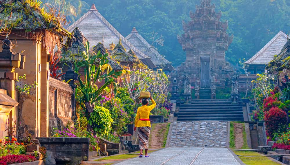 Someone carrying a basket walking through Penglipuran, an old village in Bali