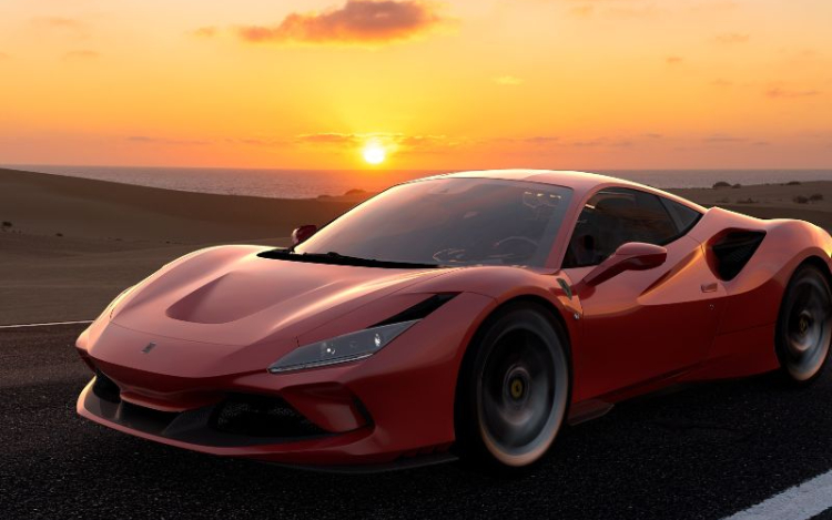 A red Ferrari driving on a road at sunset