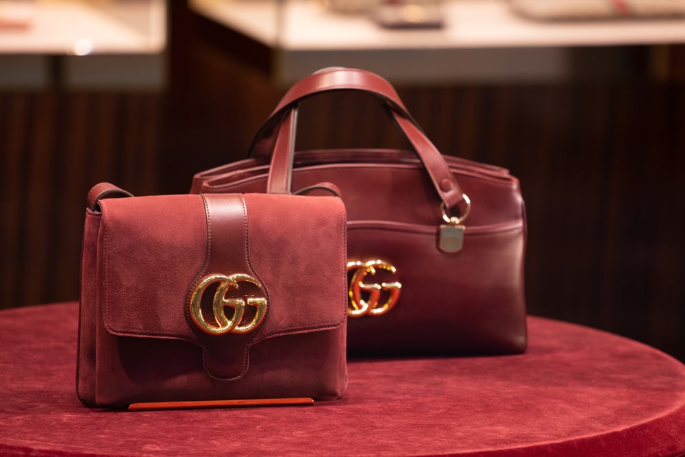 Two maroon-coloured Gucci bags displayed on a round table