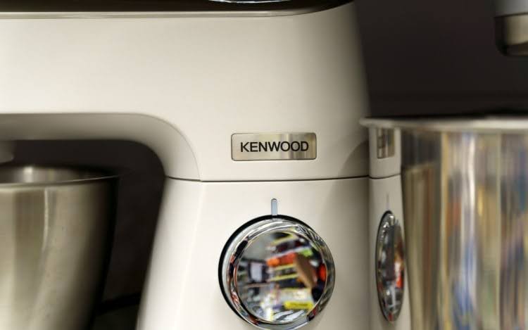 A close-up of a white Kenwood mixer with a large silver dial.