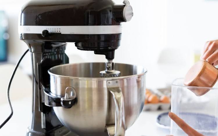 A black stand mixer with a silver bowl attached at the bottom.