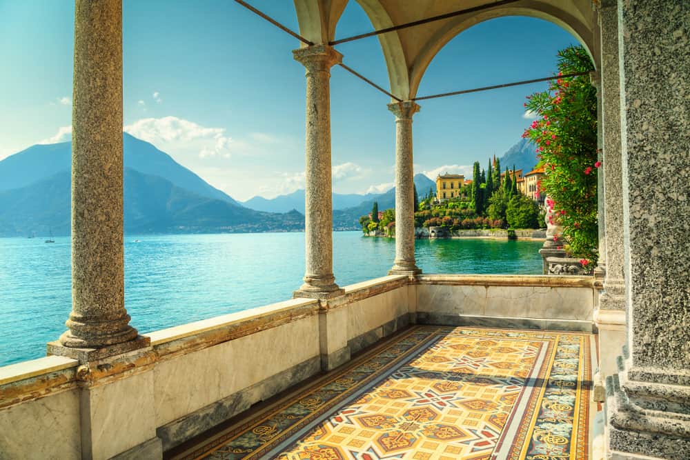 Tiled balcony with view of a villa, the lake and mountains