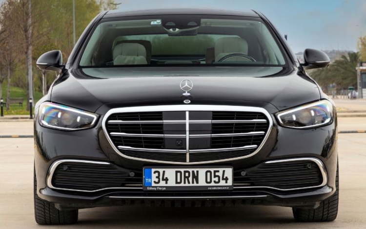 The front-facing view of a black Mercedes car, with silver detailing around the grille and headlights.