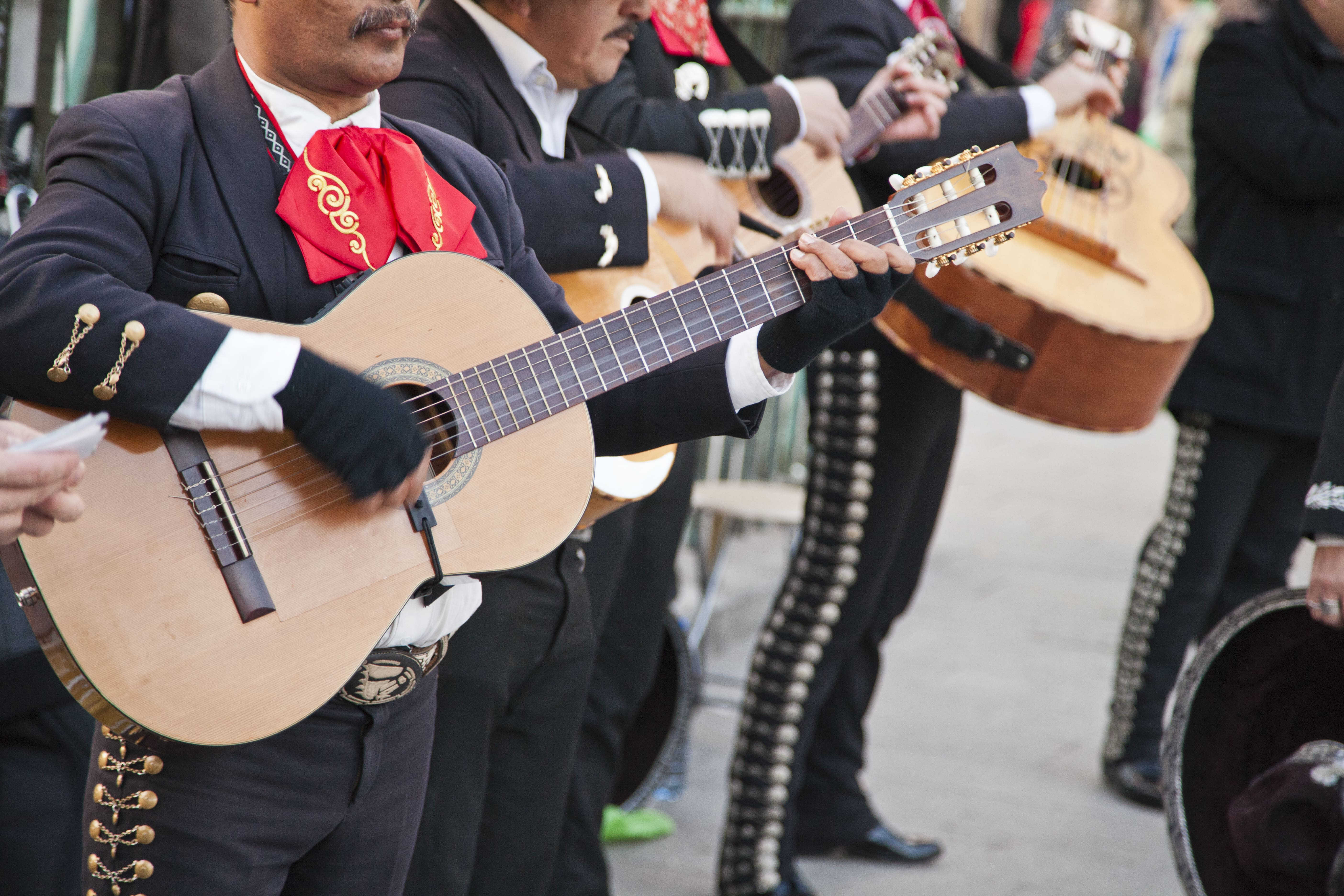  Group of typical Flamenco guitarists playing in the street wearing traditional suits.