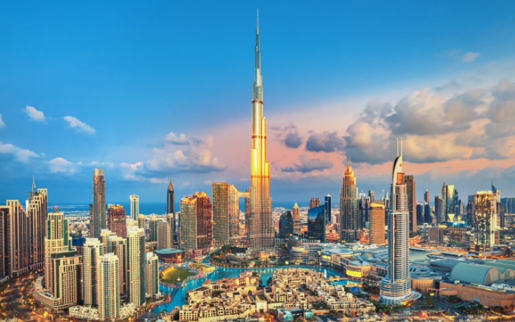 A view of several tall buildings in Dubai, including the Burj Khalifa, which is reflecting the sunlight.