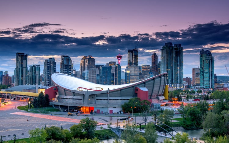 There are several skyscrapers and the silver Scotiabank Saddledome sports arena sits in the centre of the image