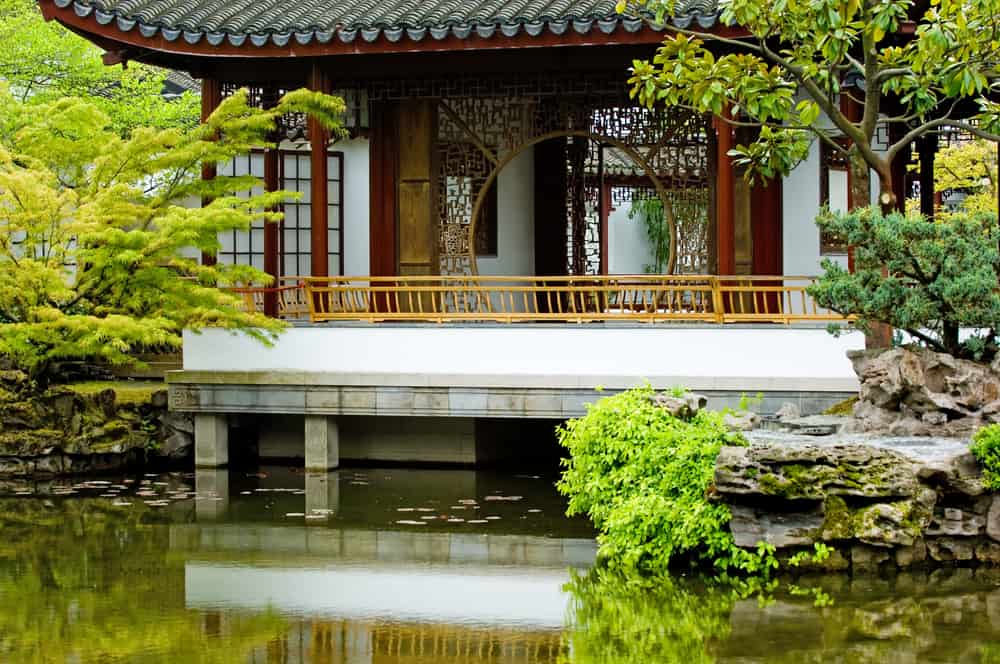 Traditional Chinese pagoda next to a riverbed surrounded by plants and rocks