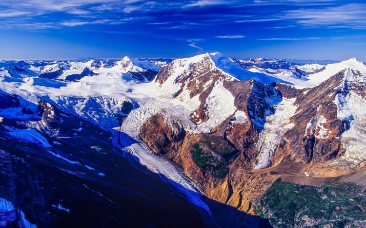 An aerial view of a mountain range covered in snow.