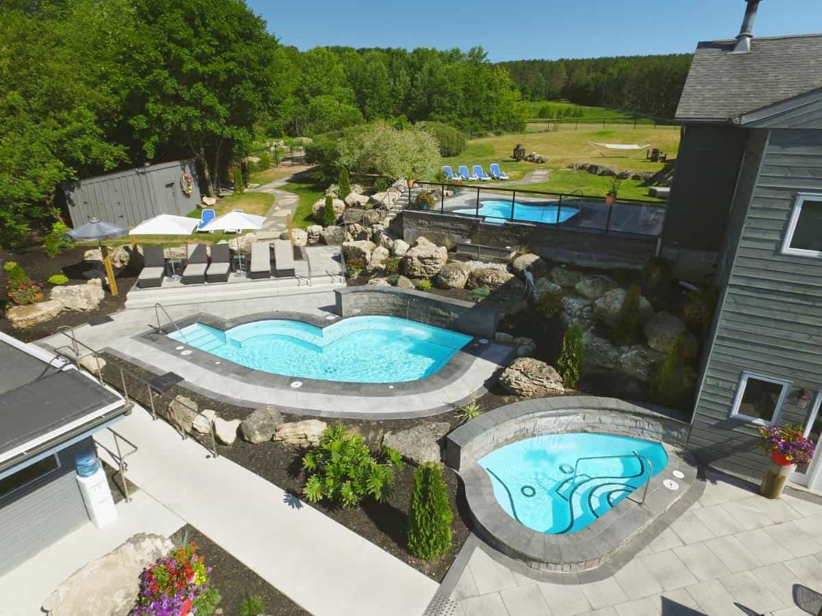 Two small pools with grass fields behind and spa buildings surrounding