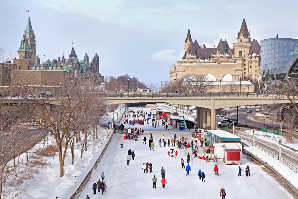 View of rideau canal skating rink with bridge and buildings in the background