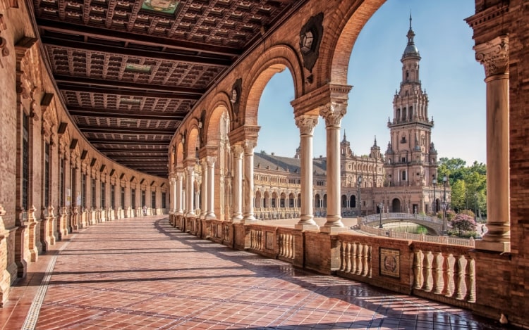 A view from the veranda of Seville’s Plaza de España, an ornate brown building with tiled floors.