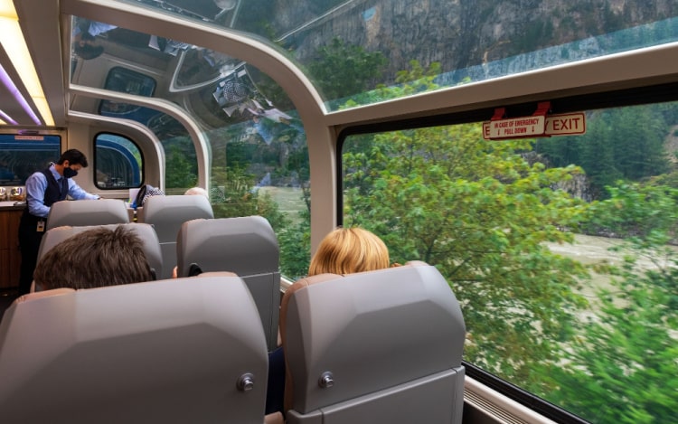 A partial view inside a train carriage with windows that extend to the roof.