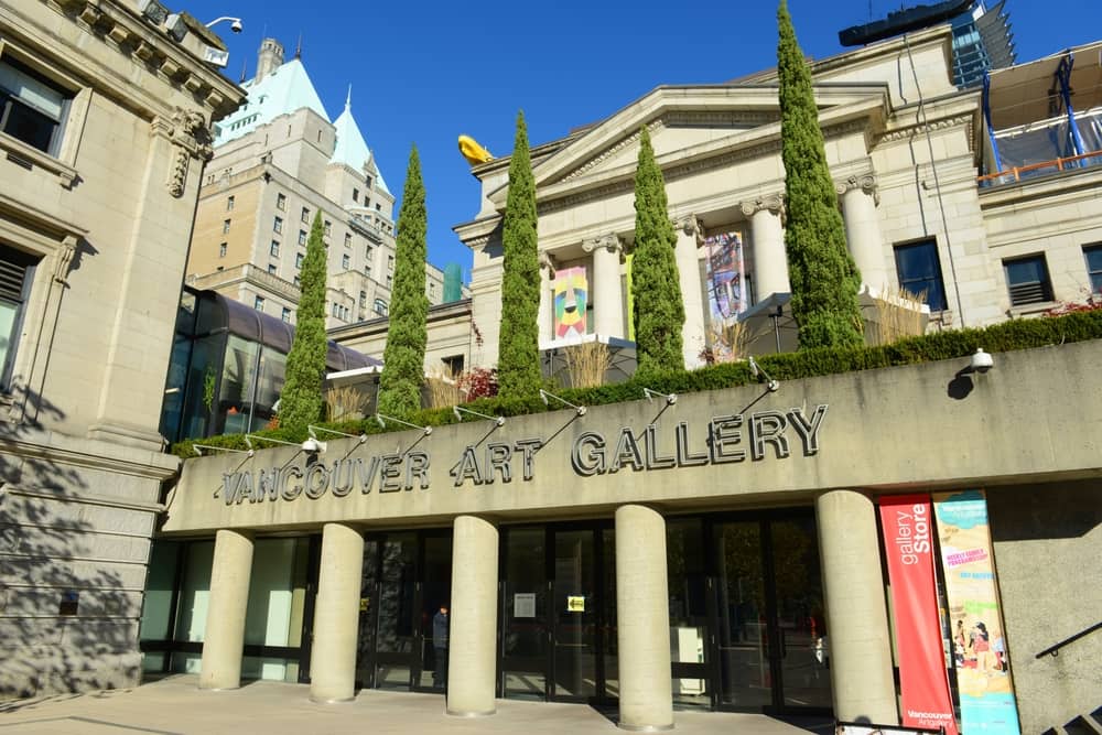 Vancouver Art Gallery entrance with five trees on top surrounded by other taller buildings