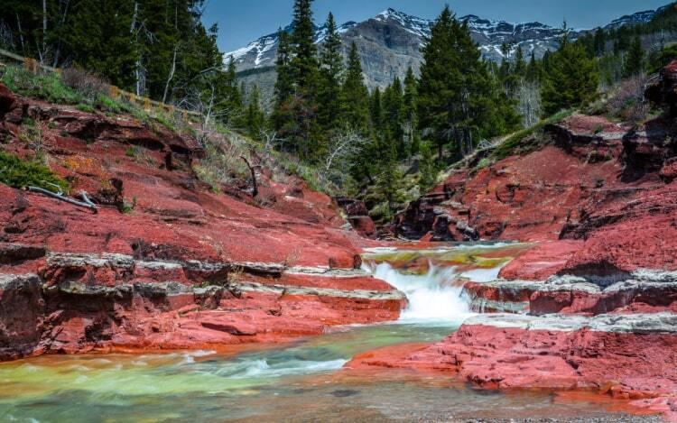 Red Rock Creek with a stream running through it. There is a mountain and woodlands in the background.