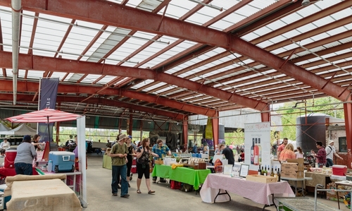 A view of the market at Evergreen Brick Works in Toronto. You can see people walking around and browsing the market.